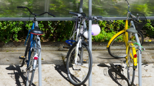Fotografía de bicicletas aseguradas con cadenas, candados o barras en el bicicletario de la Facultad