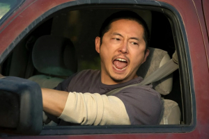 joven con rasgos asiáticos gritando por la ventanilla de un auto