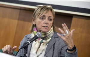 fotografía de alejandra lópez hablando al micrófono en una actividad académica