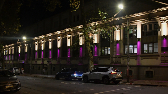 Fachada del edificio central de la Facultad de Psicología iluminada de color violeta