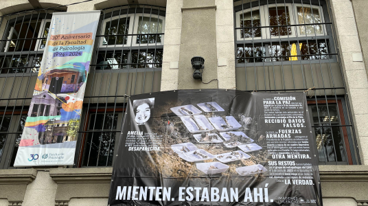 Fotografía de la fachada del edificio central de la Facultad con mural del proyecto fotográfico Imágenes del Silencio